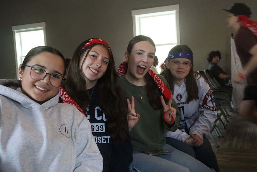 Four friends in bandanas throwing peace signs