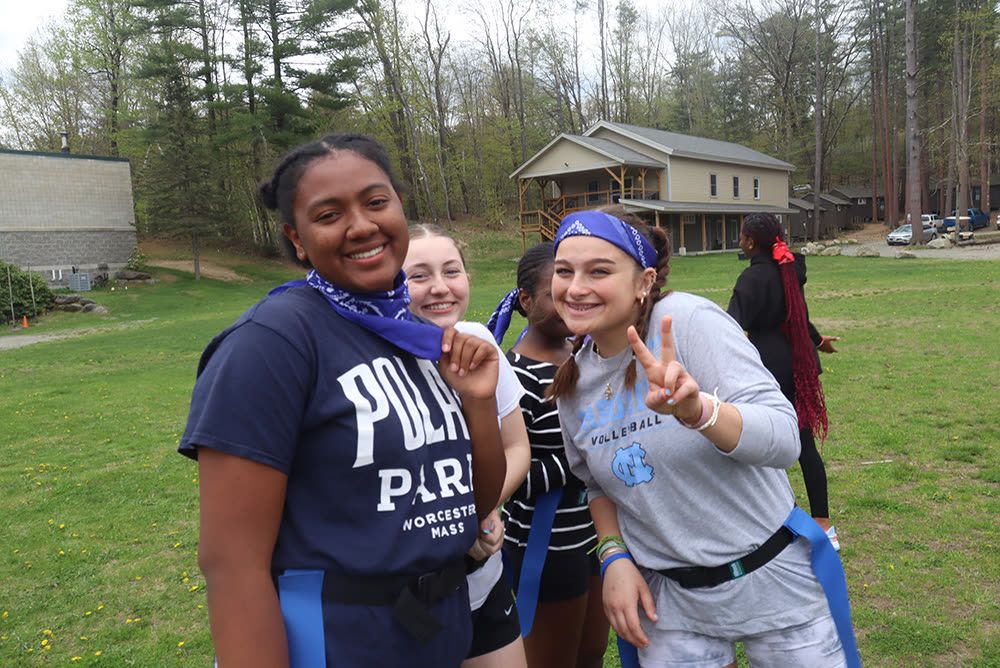 Students in flag football belts smiling on the camp field
